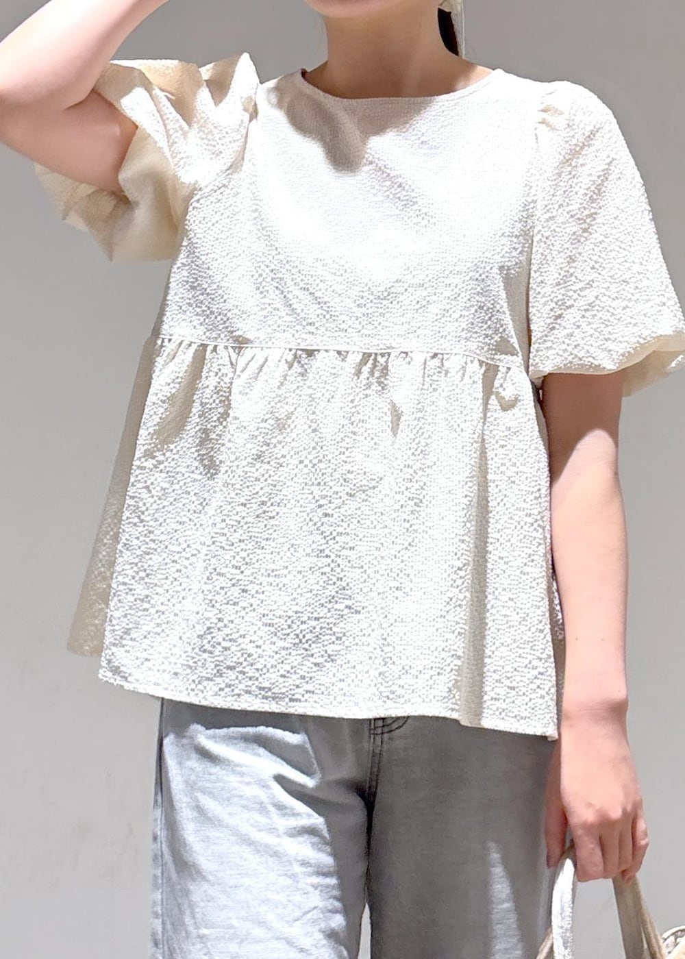 グレー系のデニムパンツ、ホワイト系のサンダル、ホワイト系のシャツ/ブラウスを着用したレディースの夏コーディネートの6枚目の写真