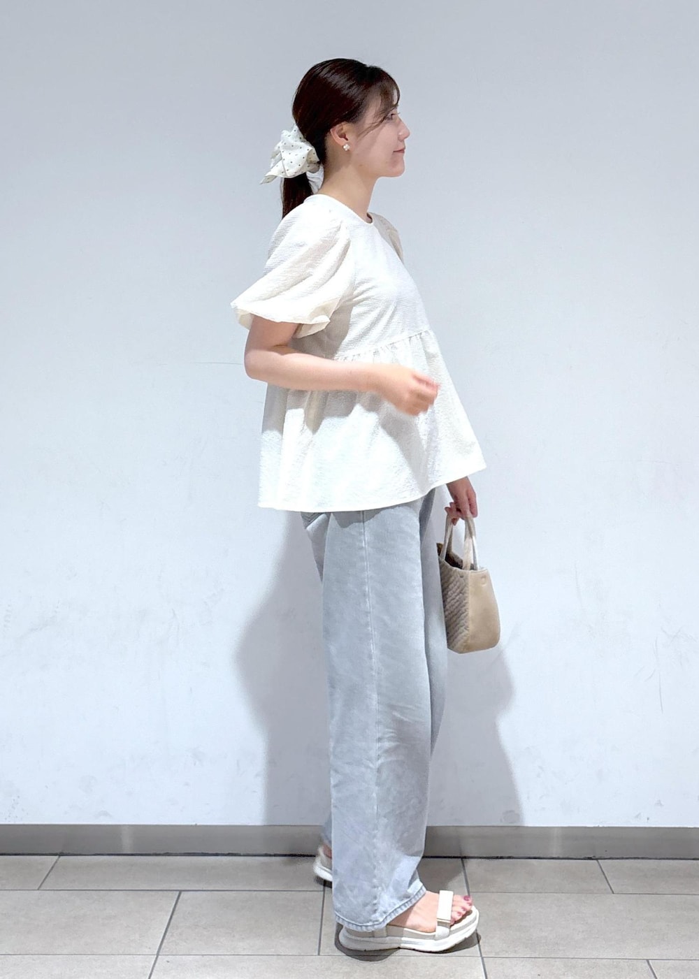 グレー系のデニムパンツ、ホワイト系のサンダル、ホワイト系のシャツ/ブラウスを着用したレディースの夏コーディネートの5枚目の写真