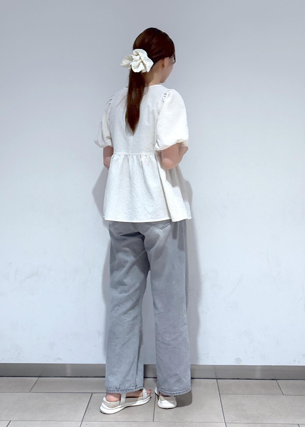 グレー系のデニムパンツ、ホワイト系のサンダル、ホワイト系のシャツ/ブラウスを着用したレディースの夏コーディネートの4枚目の写真