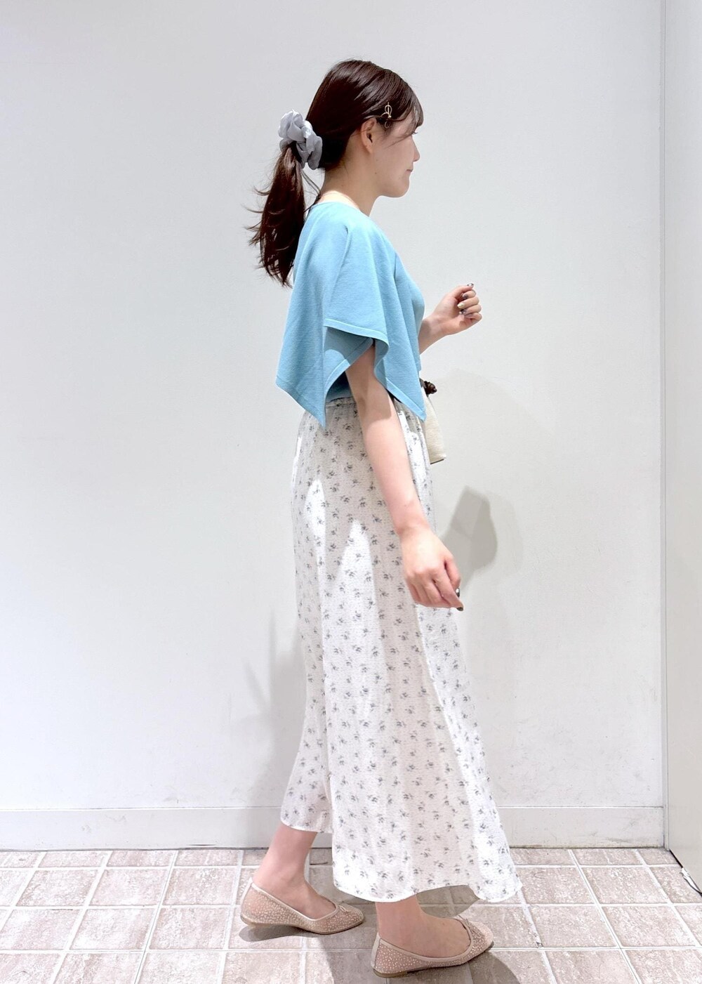 ホワイト系のスカート、ブルー系のニット/セーター、ホワイト系のバレエシューズを着用したレディースの春コーディネートの4枚目の写真