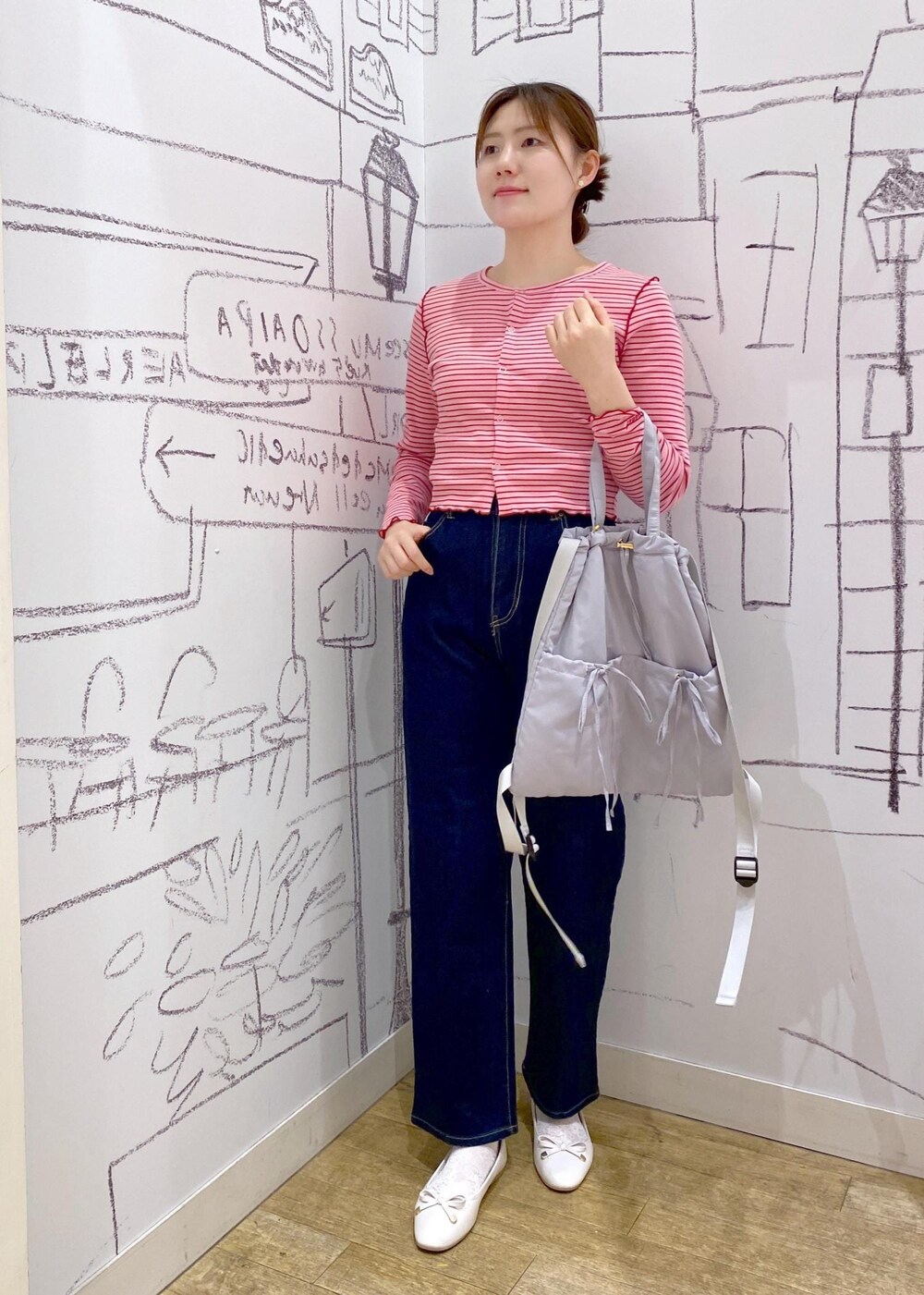 ピンク系のカーディガン/ボレロ、グレー系のバックパック/リュック、ブルー系のデニムパンツを着用したレディースの春コーディネートの4枚目の写真