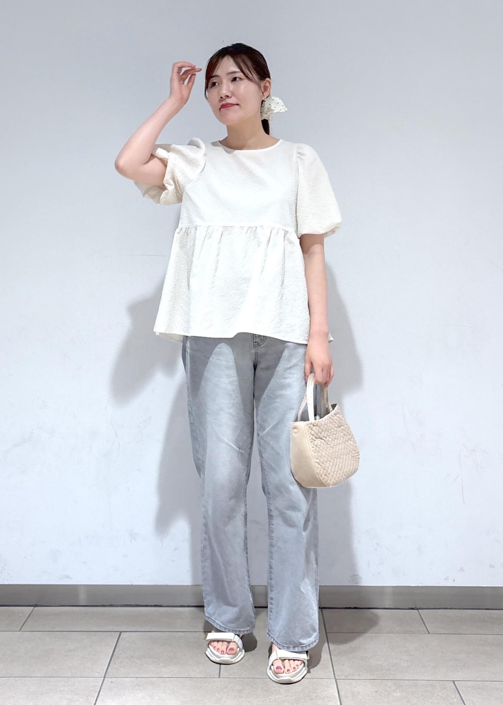 グレー系のデニムパンツ、ホワイト系のサンダル、ホワイト系のシャツ/ブラウスを着用したレディースの夏コーディネートの2枚目の写真