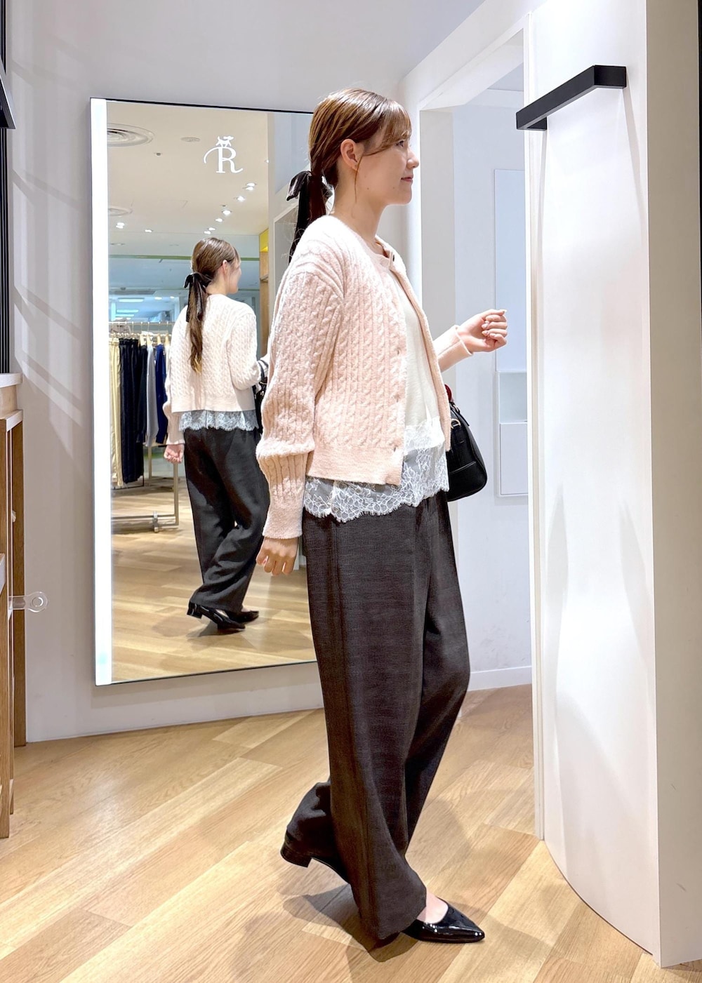 ホワイト系のキャミソール、ブラック系のパンプス、ピンク系のカーディガン/ボレロを着用したレディースの秋コーディネートの4枚目の写真