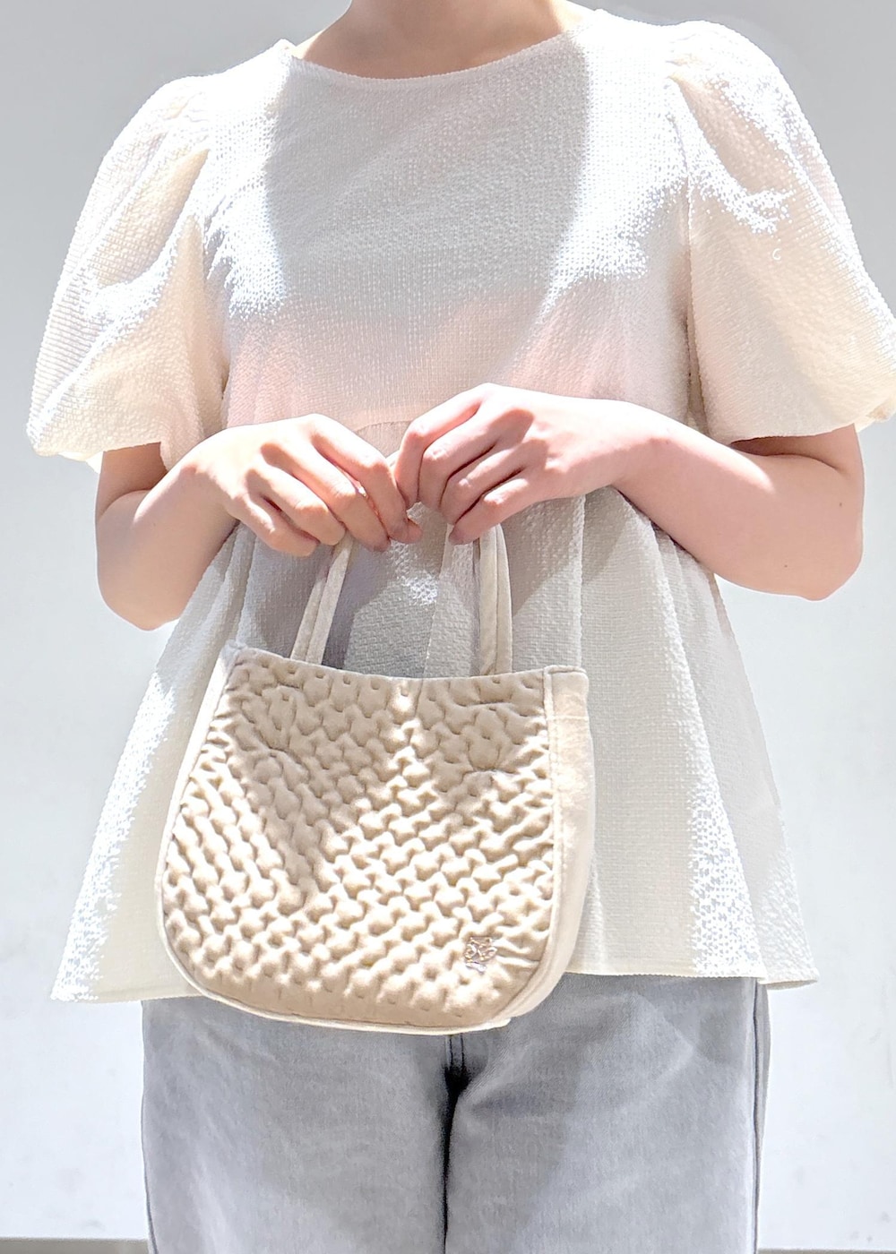 グレー系のデニムパンツ、ホワイト系のサンダル、ホワイト系のシャツ/ブラウスを着用したレディースの夏コーディネートの7枚目の写真