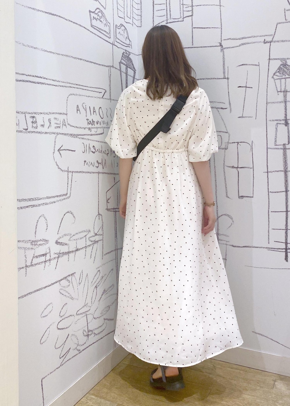 ブラック系のボディバッグ/ウエストポーチ、ブルー系のサンダル、ホワイト系のワンピースを着用したレディースの春コーディネートの2枚目の写真