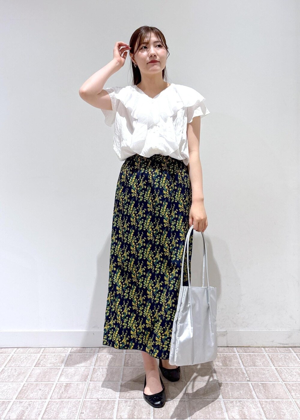 ブラック系のバレエシューズ、シルバー系のトートバッグ、ブルー系のスカートを着用したレディースの夏コーディネートの5枚目の写真