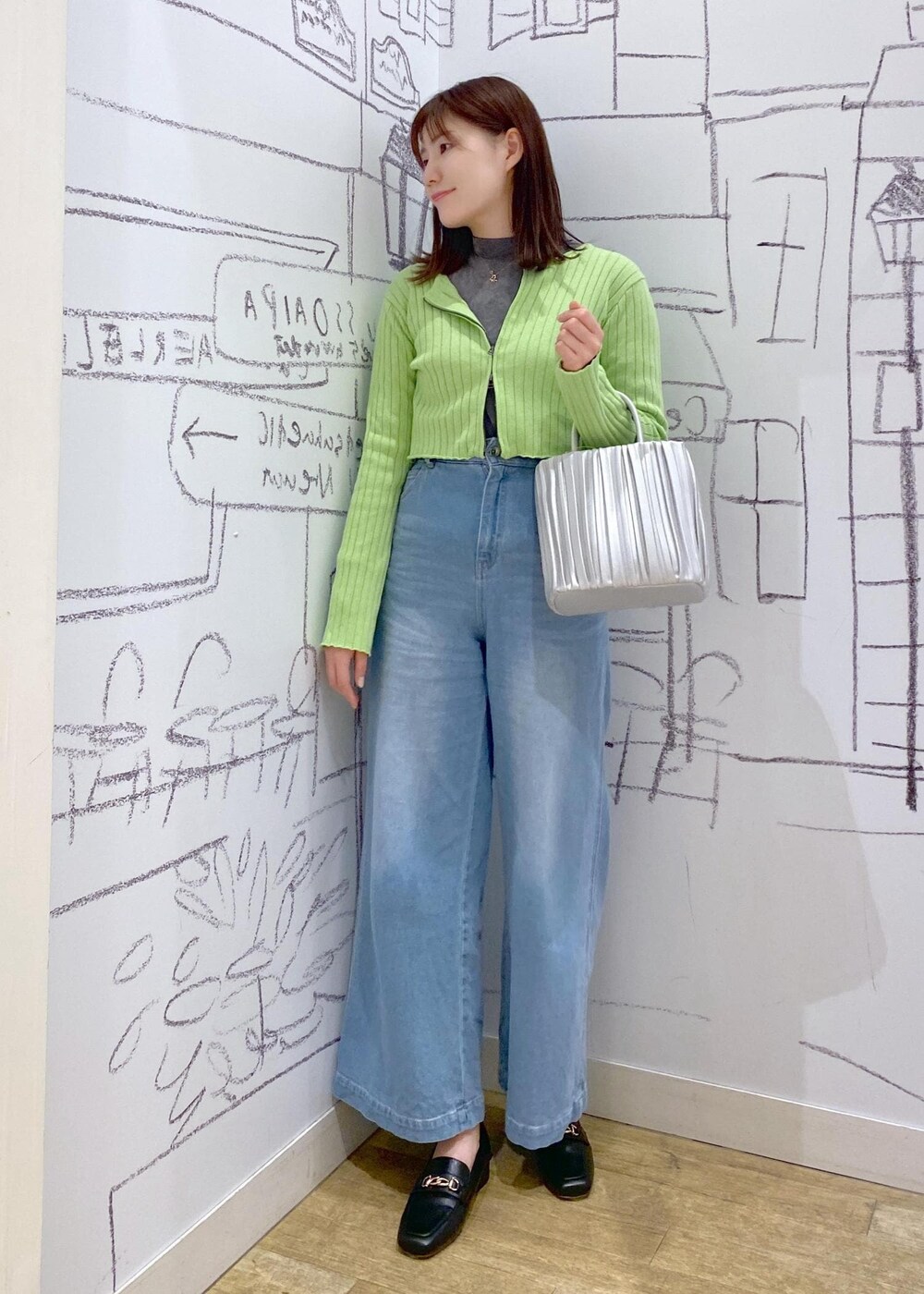 シルバー系のハンドバッグ、グレー系のTシャツ/カットソー、ブラック系のローファーを着用したレディースの冬コーディネートの2枚目の写真