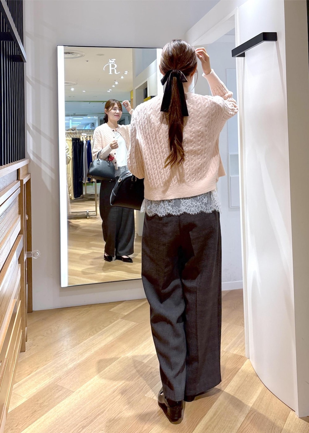ホワイト系のキャミソール、ブラック系のパンプス、ピンク系のカーディガン/ボレロを着用したレディースの秋コーディネートの3枚目の写真