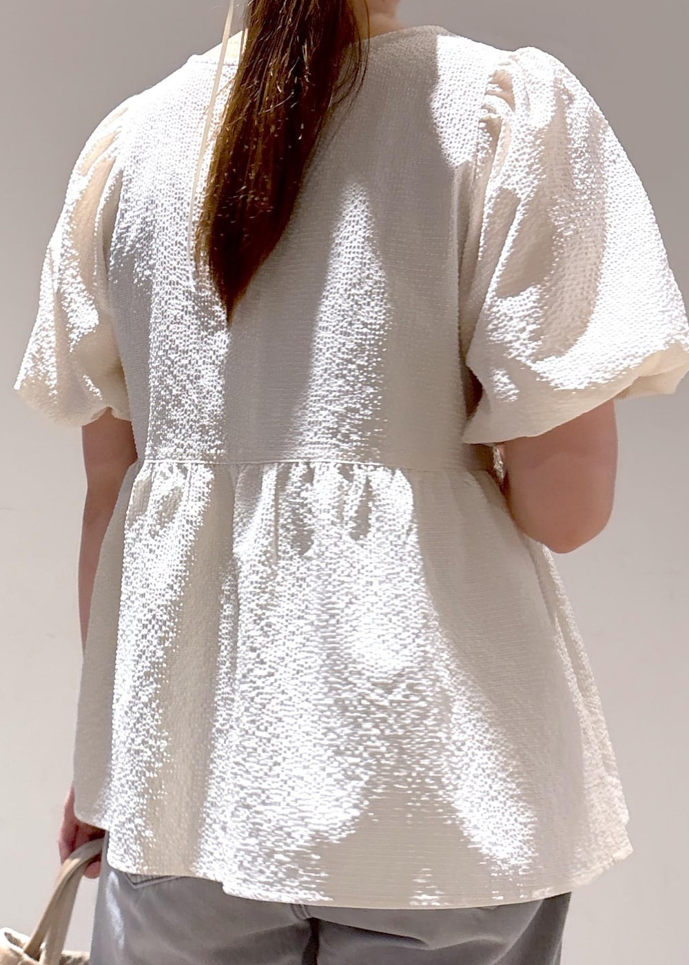 グレー系のデニムパンツ、ホワイト系のサンダル、ホワイト系のシャツ/ブラウスを着用したレディースの夏コーディネートの8枚目の写真