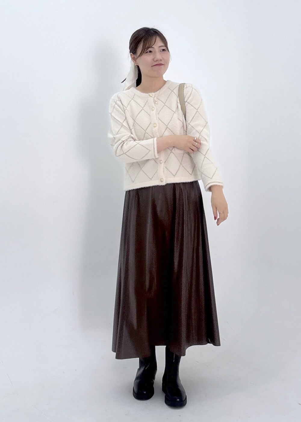 ブラウン系のスカート、ホワイト系のカーディガン/ボレロを着用したレディースの夏コーディネートの2枚目の写真