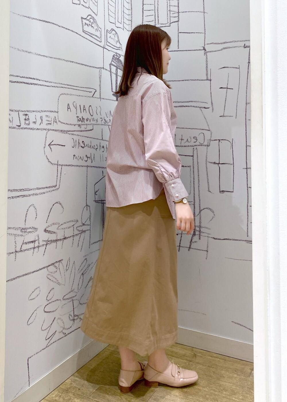 ピンク系のローファー、レッド系のシャツ/ブラウス、ベージュ系のスカートを着用したレディースの冬コーディネートの3枚目の写真