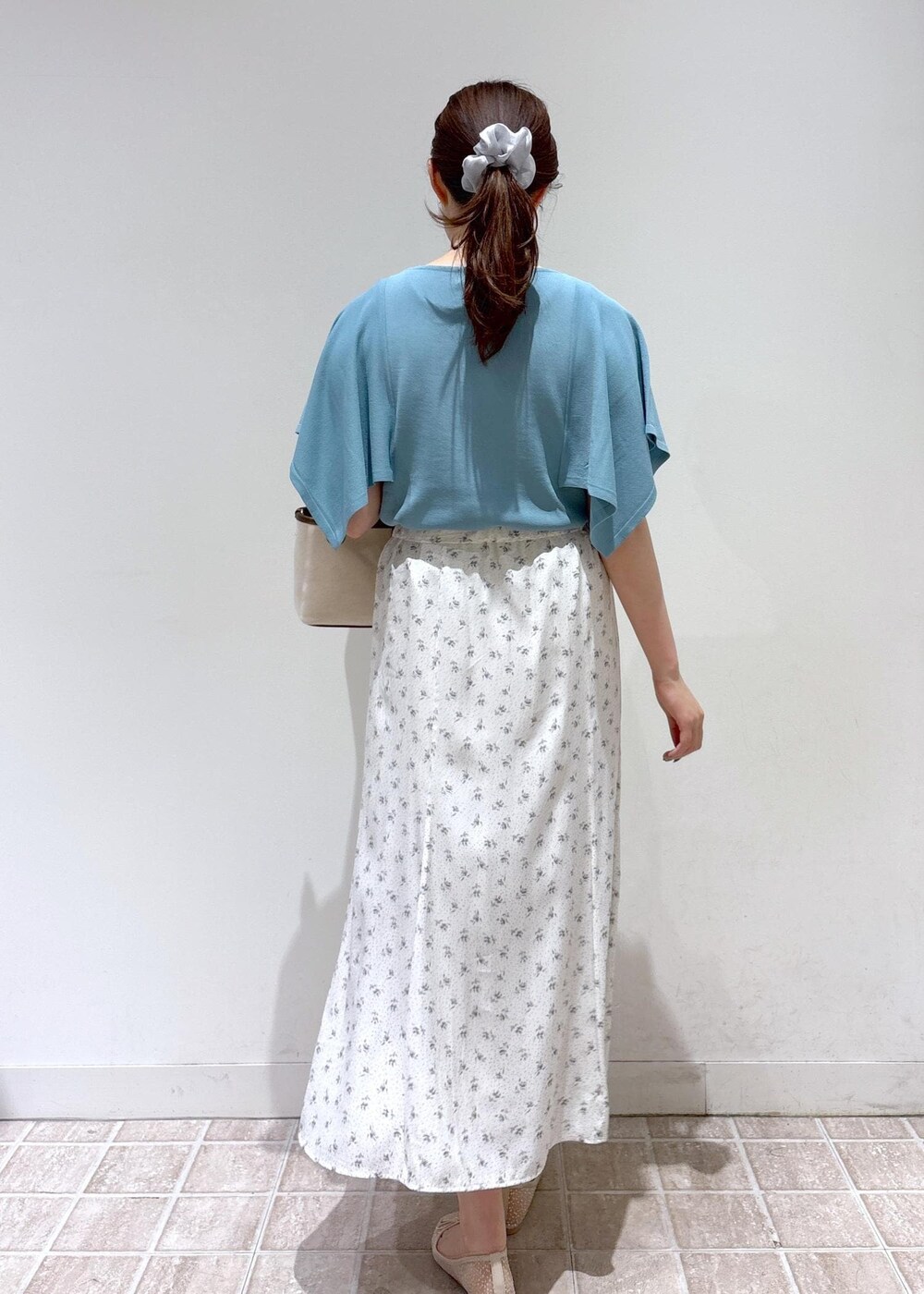 ホワイト系のスカート、ブルー系のニット/セーター、ホワイト系のバレエシューズを着用したレディースの春コーディネートの3枚目の写真