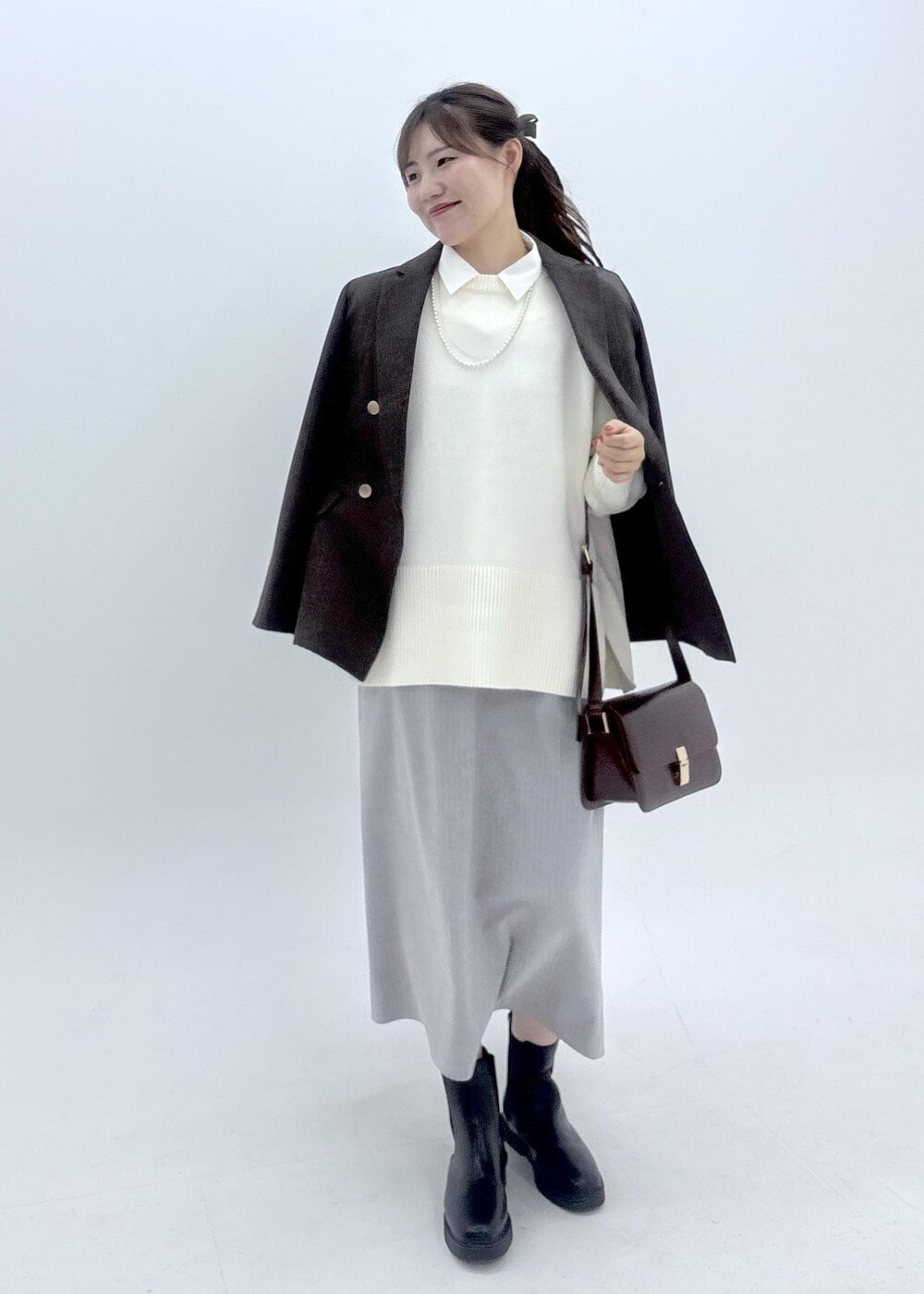 グレー系のワンピース、ホワイト系のシャツ/ブラウス、ホワイト系のニット/セーターを着用したレディースの夏コーディネートの2枚目の写真