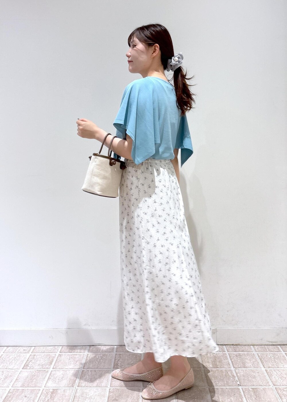 ホワイト系のスカート、ブルー系のニット/セーター、ホワイト系のバレエシューズを着用したレディースの春コーディネートの2枚目の写真