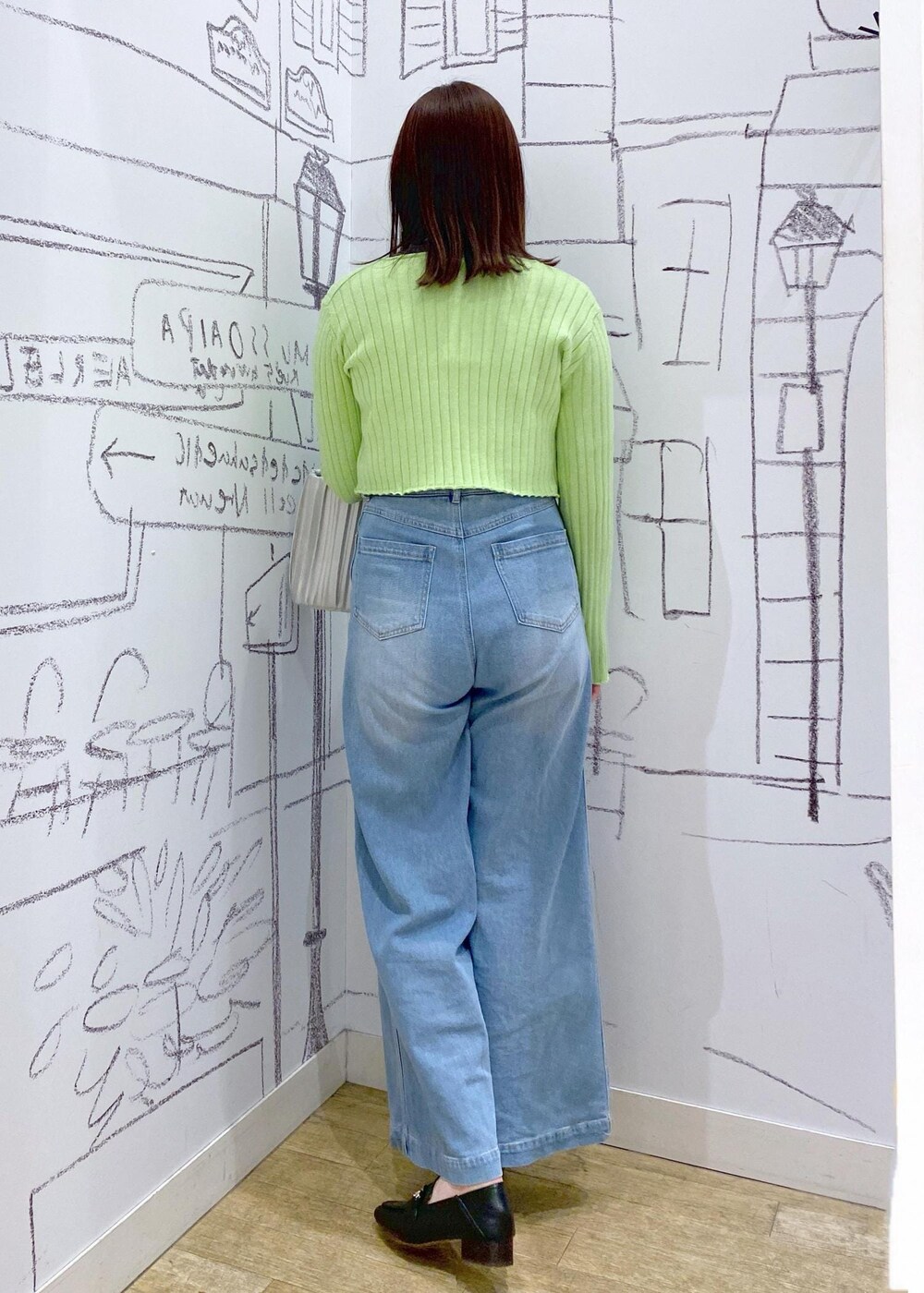 シルバー系のハンドバッグ、グレー系のTシャツ/カットソー、ブラック系のローファーを着用したレディースの冬コーディネートの3枚目の写真