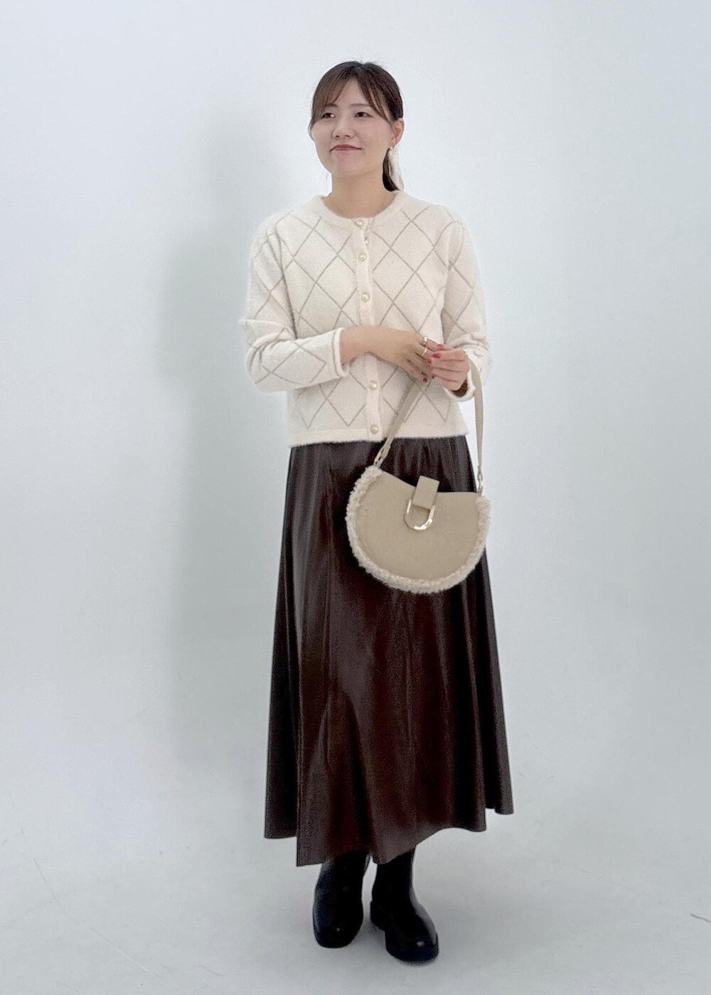 ブラウン系のスカート、ホワイト系のカーディガン/ボレロを着用したレディースの夏コーディネートの6枚目の写真