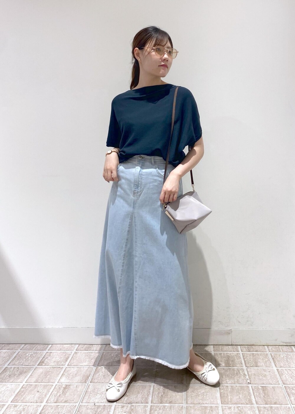 グレー系のショルダーバッグ、ブルー系のデニムスカート、グリーン系のニット/セーターを着用したレディースの夏コーディネートの5枚目の写真