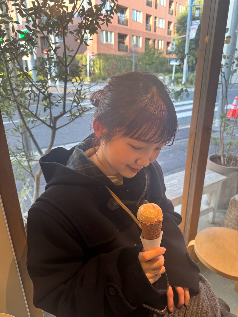 ブルー系のダッフルコート、ベージュ系のショルダーバッグ、ベージュ系のスカートを着用したレディースの冬コーディネートの2枚目の写真