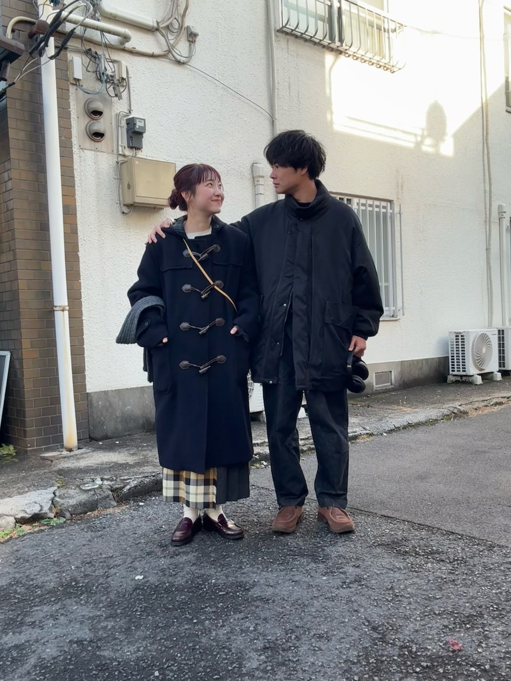 ブルー系のダッフルコート、ベージュ系のショルダーバッグ、ベージュ系のスカートを着用したレディースの冬コーディネートの3枚目の写真