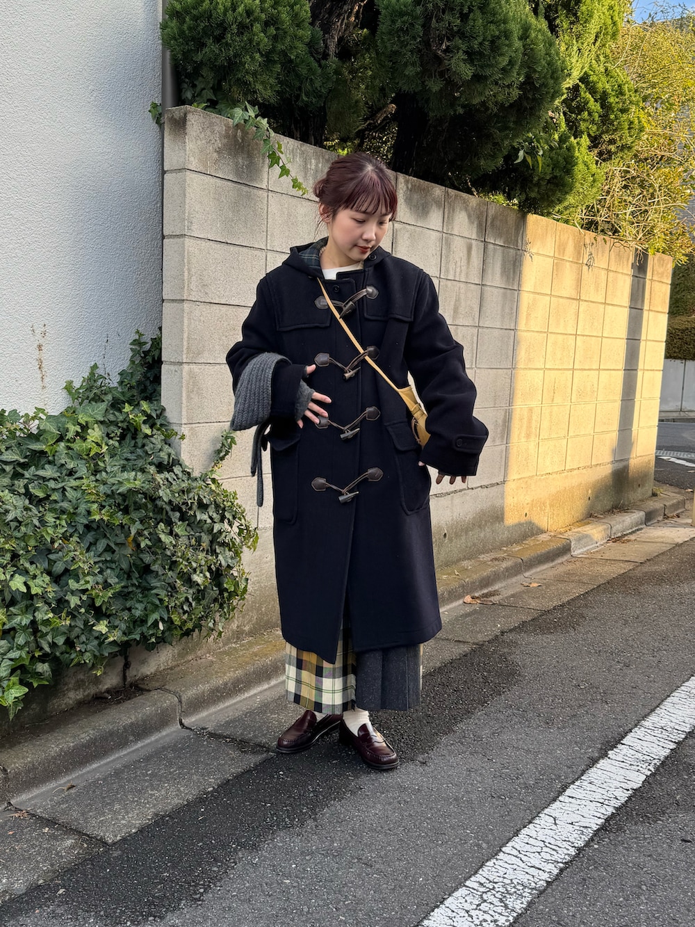 ブルー系のダッフルコート、ベージュ系のショルダーバッグ、ベージュ系のスカートを着用したレディースの冬コーディネートの4枚目の写真