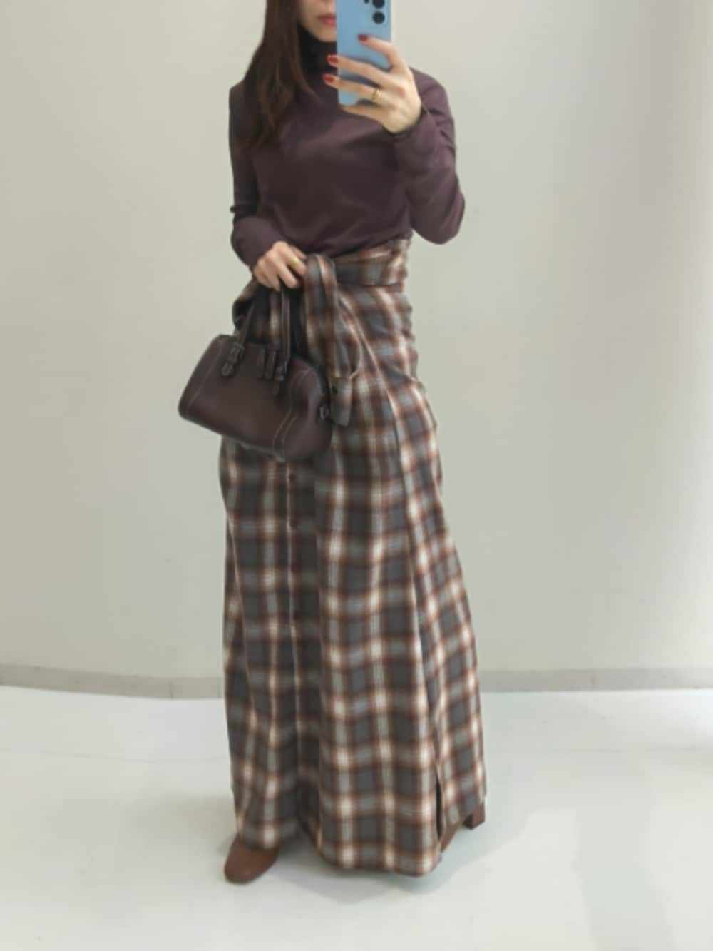 ブラウン系のワンピース、イエロー系のTシャツ/カットソー、ブラック系のTシャツ/カットソーを着用したレディースの秋コーディネートの2枚目の写真