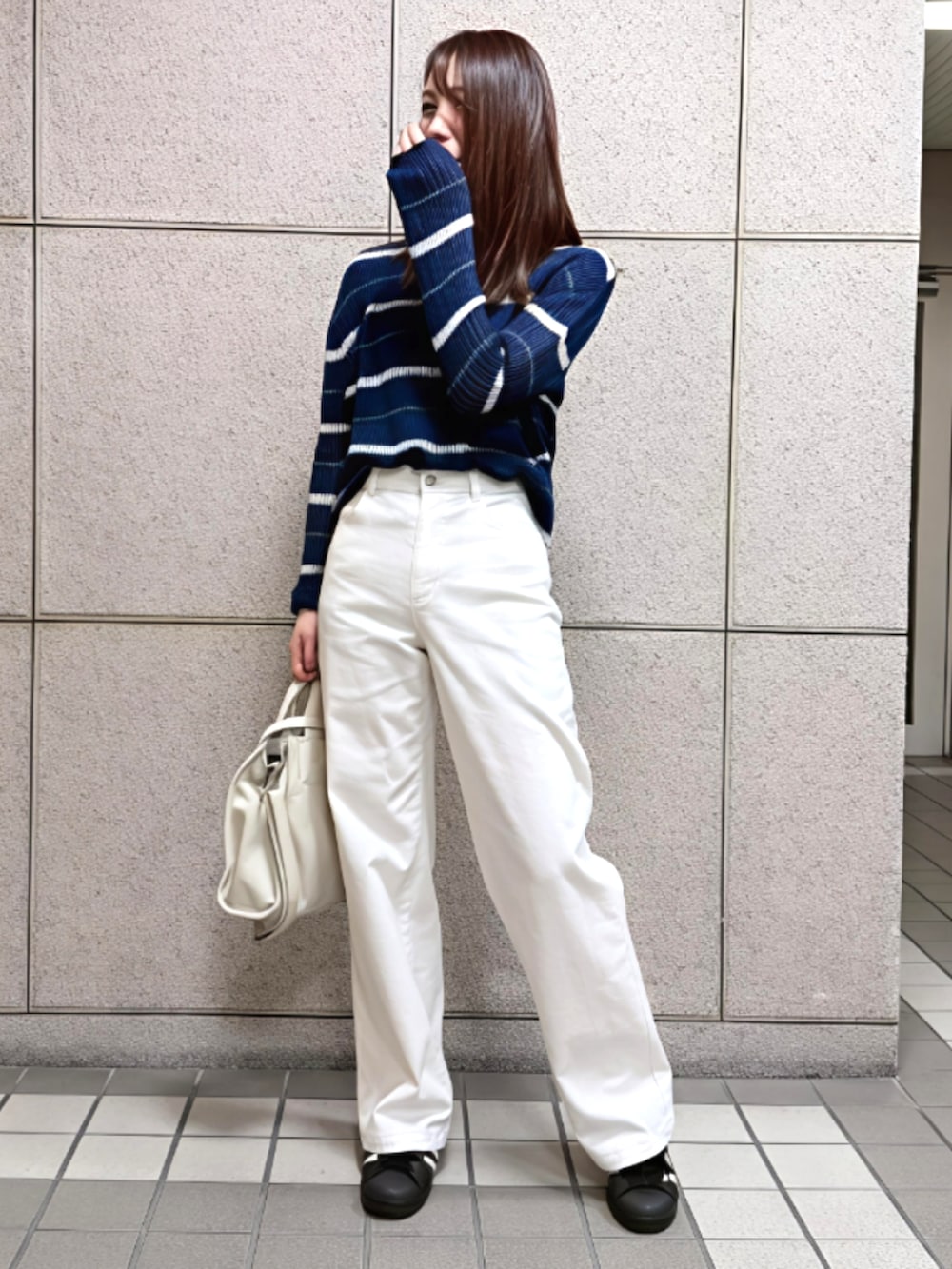 ホワイト系のデニムパンツ、ブルー系のニット/セーターを着用したレディースの春コーディネートの2枚目の写真