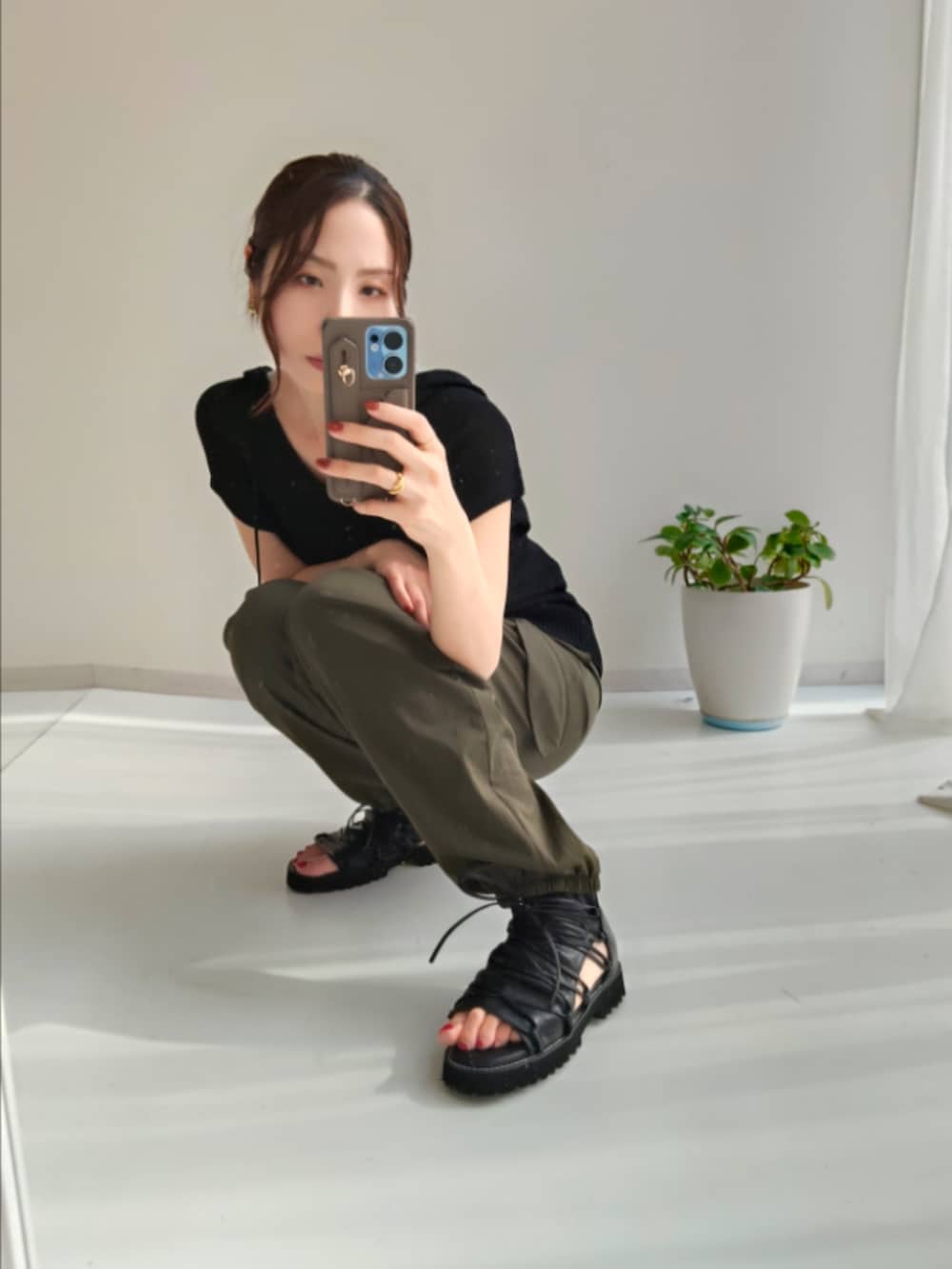 グリーン系のカーゴパンツ、グリーン系のカーゴパンツ、ブラック系のニット/セーターを着用したレディースの夏コーディネートの2枚目の写真