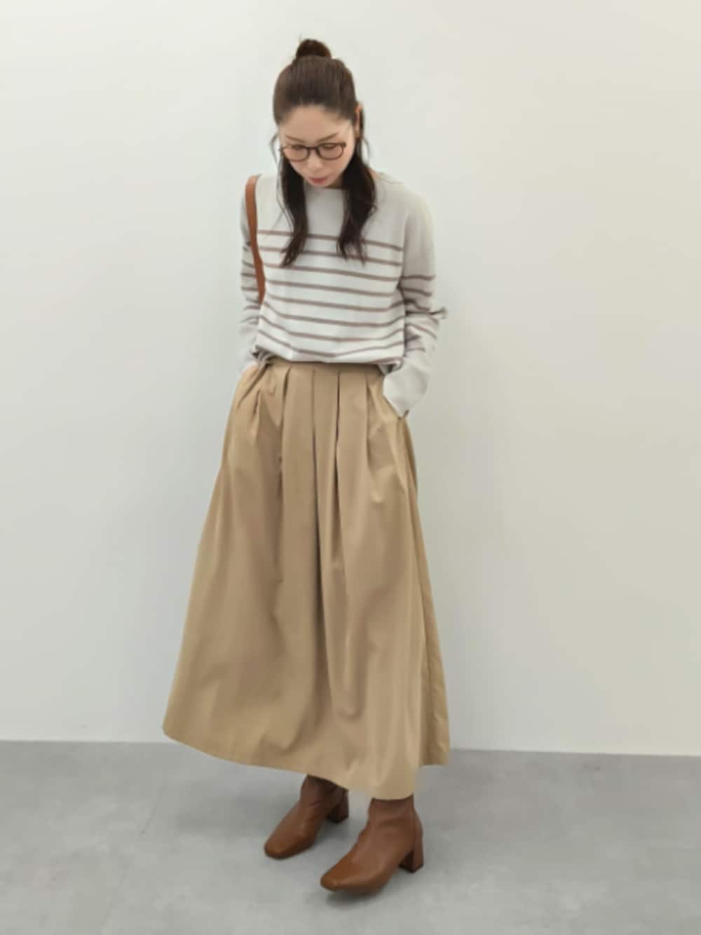 ベージュ系のスカート、ベージュ系のニット/セーター、ベージュ系のニット/セーターを着用したレディースの秋コーディネートの2枚目の写真