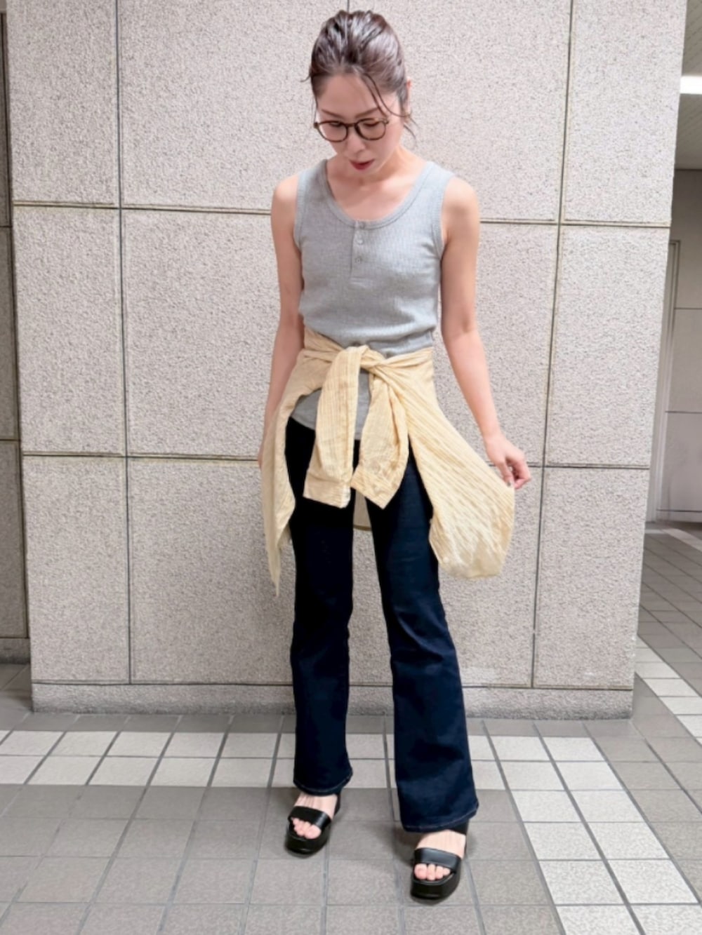 イエロー系のシャツ/ブラウス、グレー系のTシャツ/カットソー、ブルー系のデニムパンツを着用したレディースの春コーディネートの2枚目の写真