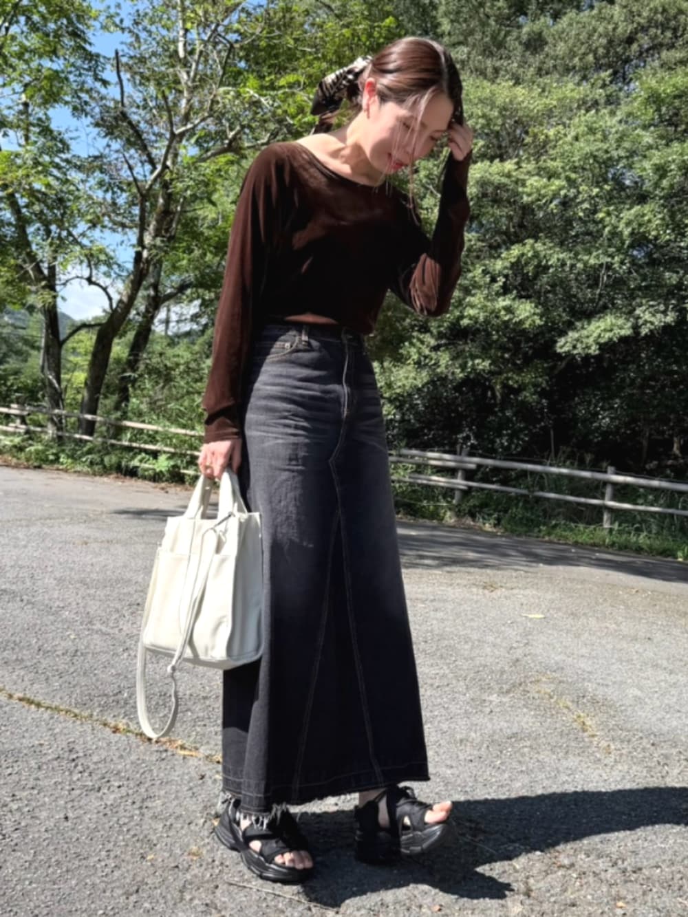 ブラウン系のTシャツ/カットソー、ブラック系のスカート、ブラック系のスカートを着用したレディースの秋コーディネートの2枚目の写真