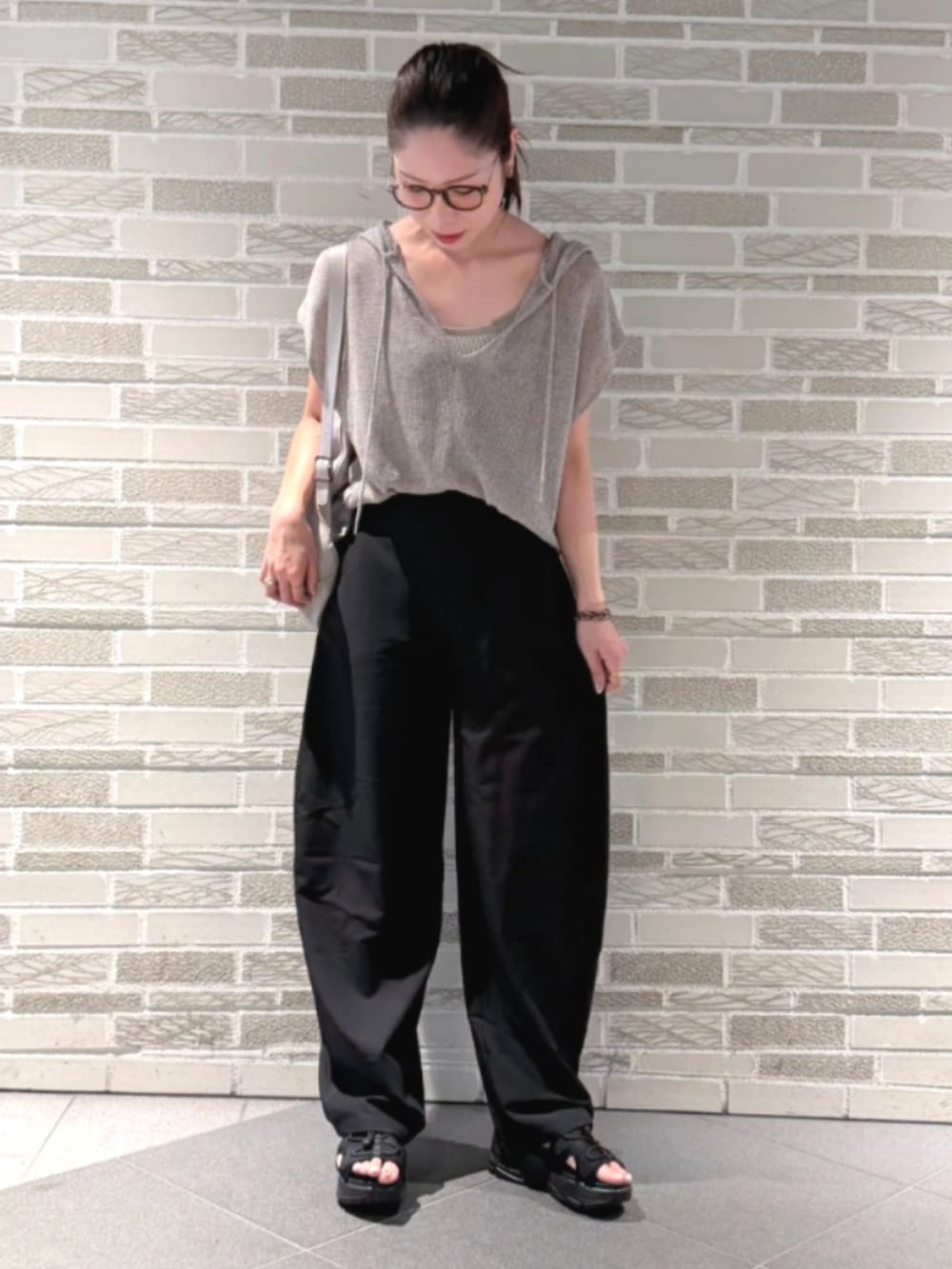 ブラック系のその他パンツ、ブラック系のパンツ、ベージュ系のニット/セーターを着用したレディースの夏コーディネートの2枚目の写真