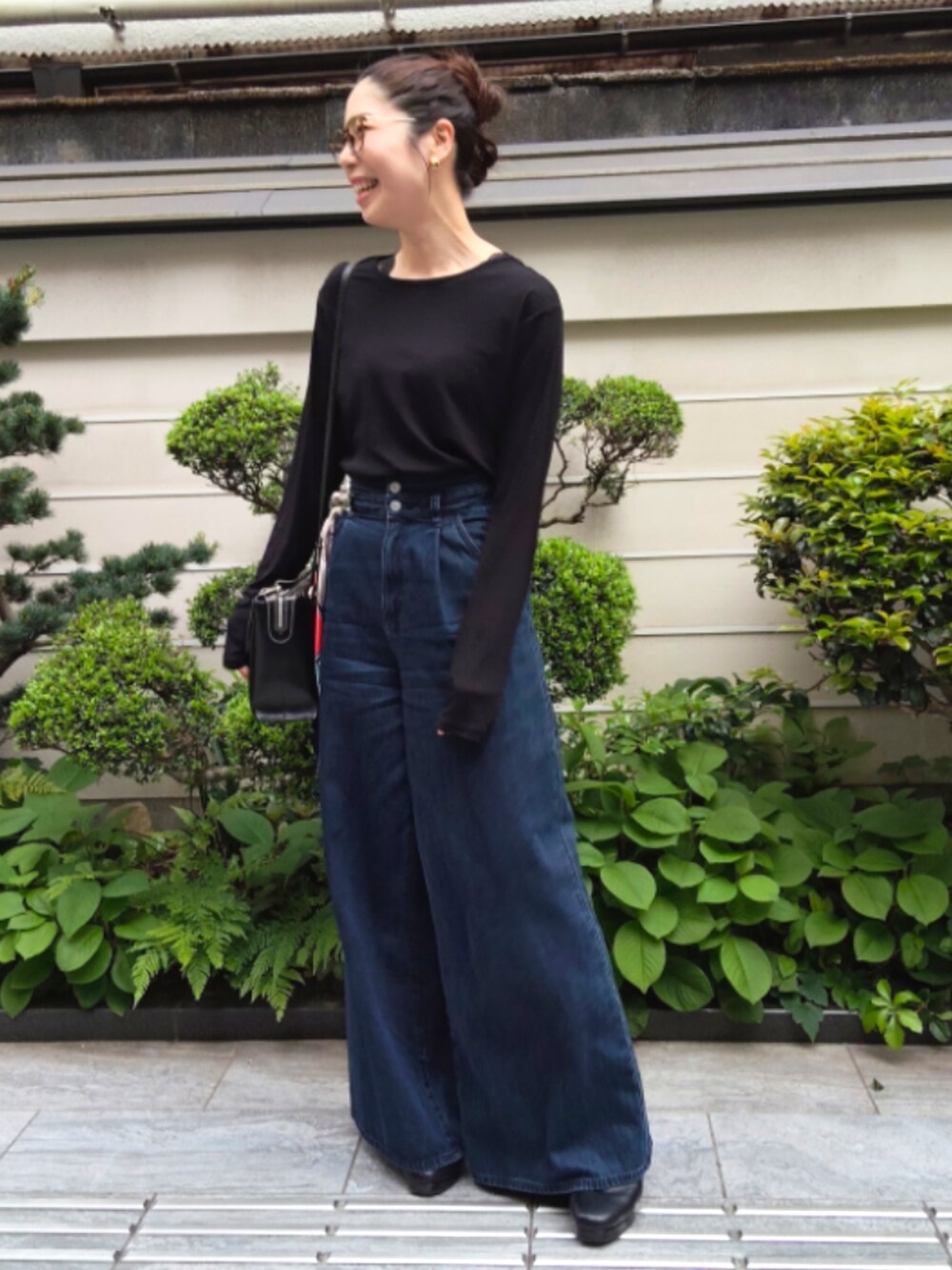 ブルー系のデニムパンツ、ブラック系のTシャツ/カットソーを着用したレディースの春コーディネートの2枚目の写真