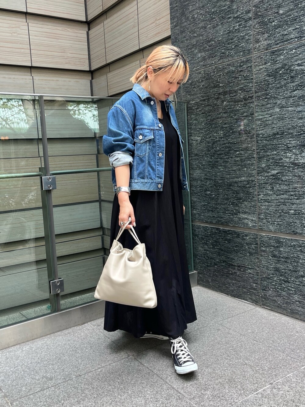 ベージュ系のショルダーバッグ、ブラック系のワンピース、シルバー系のバングル/リストバンドを着用したレディースの秋コーディネートの2枚目の写真