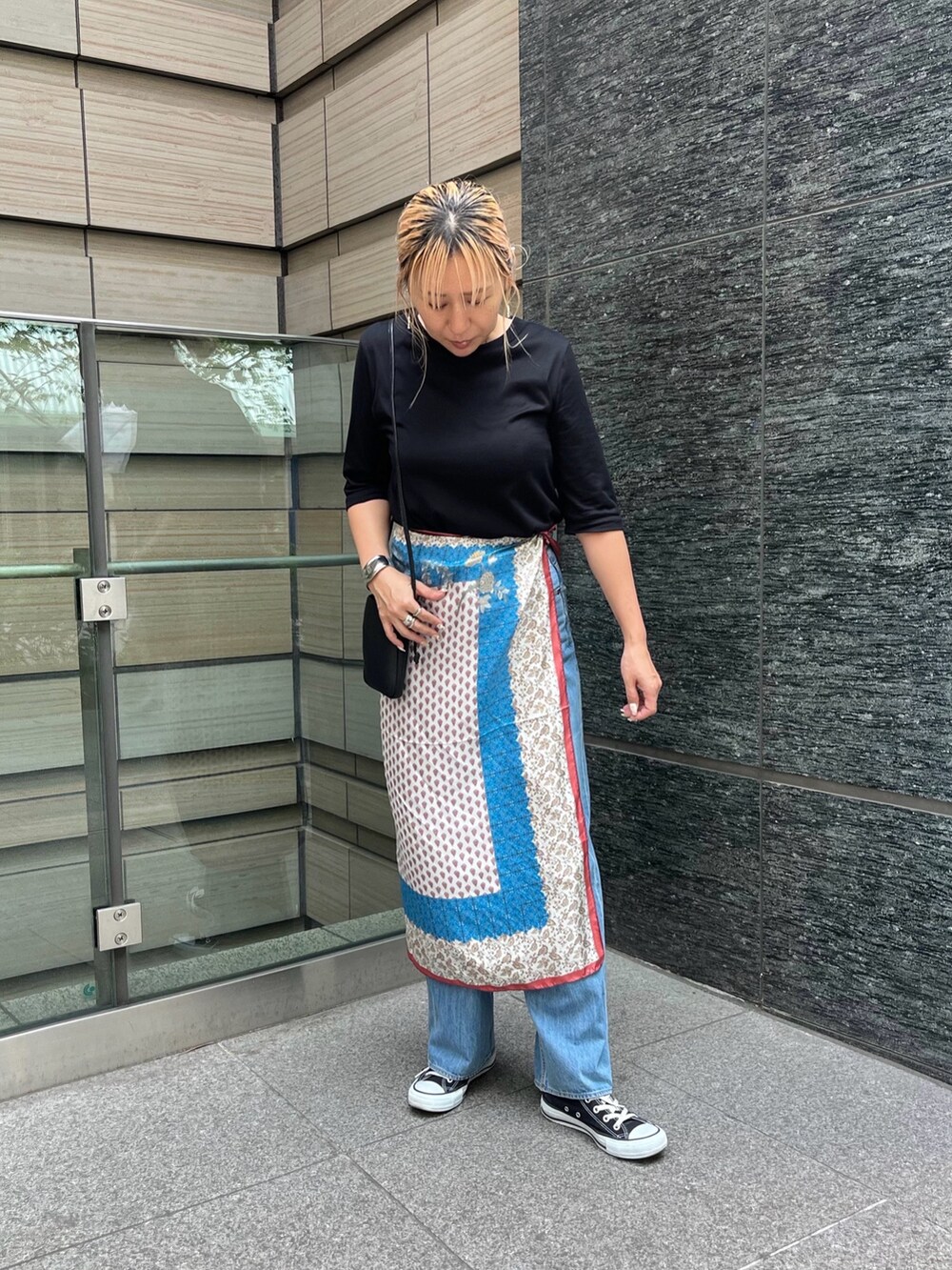 ブルー系のデニムパンツ、ブラック系のTシャツ/カットソー、ベージュ系のストール/ショールを着用したレディースの秋コーディネートの5枚目の写真