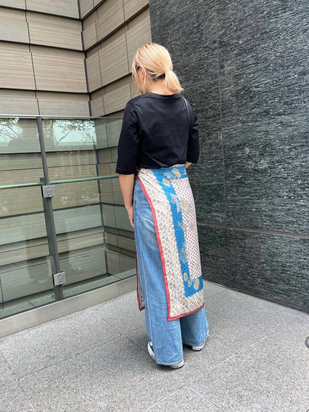 ブルー系のデニムパンツ、ブラック系のTシャツ/カットソー、ベージュ系のストール/ショールを着用したレディースの秋コーディネートの6枚目の写真