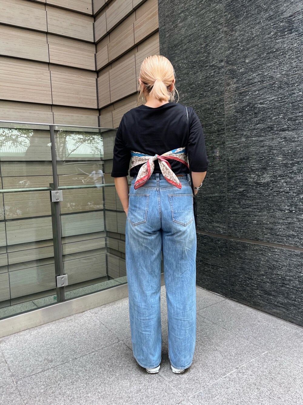 ブルー系のデニムパンツ、ブラック系のTシャツ/カットソー、ベージュ系のストール/ショールを着用したレディースの秋コーディネートの4枚目の写真