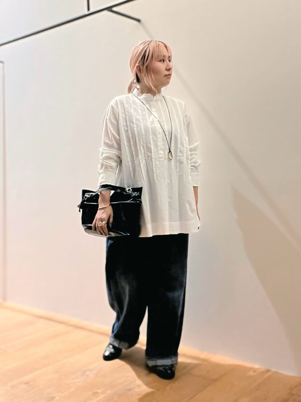 ブラック系のショルダーバッグ、ホワイト系のシャツ/ブラウス、ゴールド系のネックレスを着用したレディースの秋コーディネートの2枚目の写真