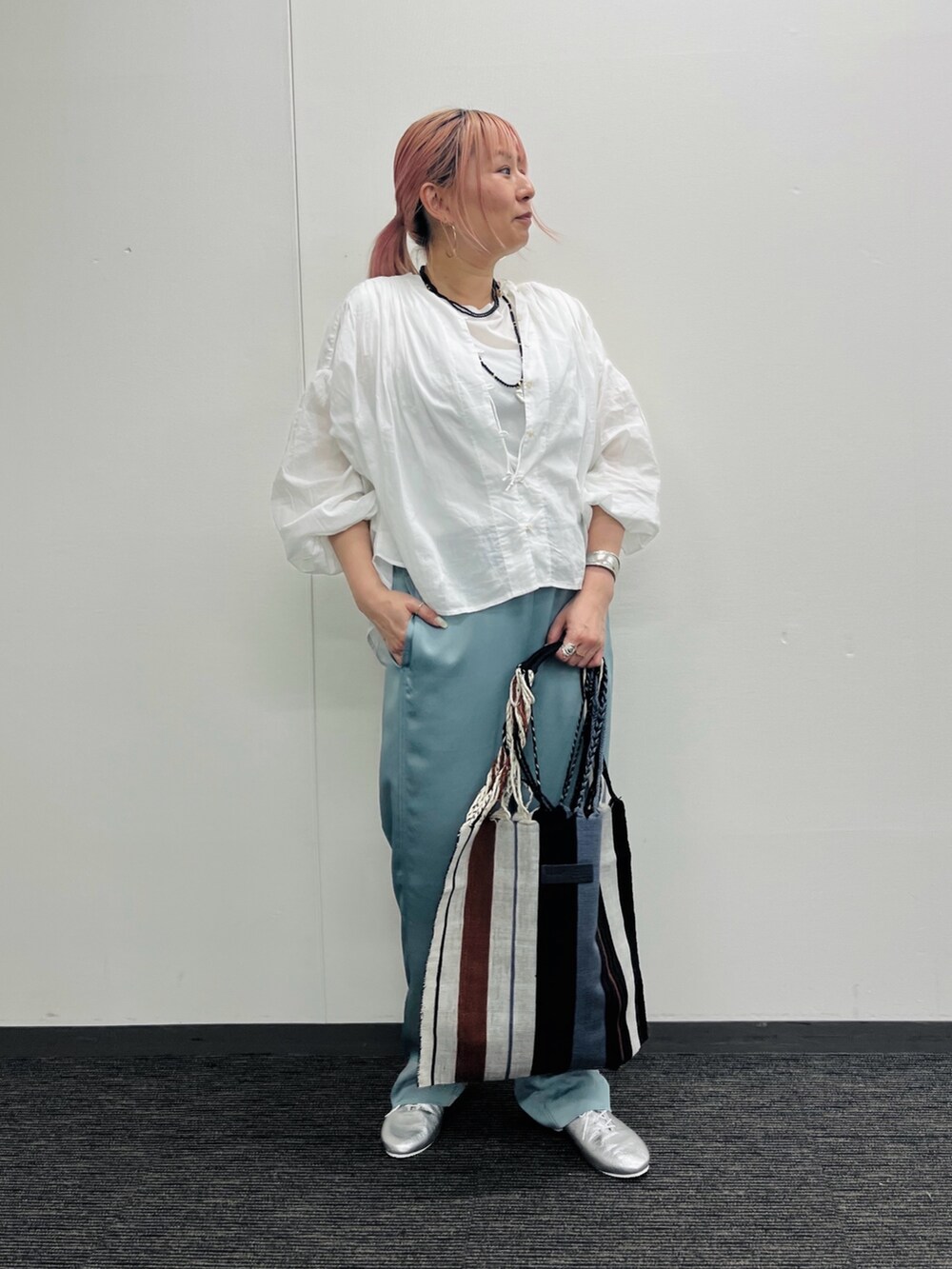 グレー系のかごバッグ、ホワイト系のシャツ/ブラウス、グリーン系のその他パンツを着用したレディースの春コーディネートの4枚目の写真