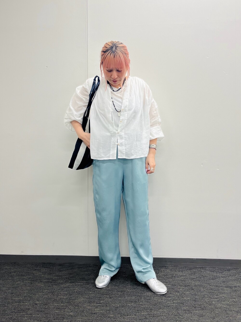 グレー系のかごバッグ、ホワイト系のシャツ/ブラウス、グリーン系のその他パンツを着用したレディースの春コーディネートの3枚目の写真