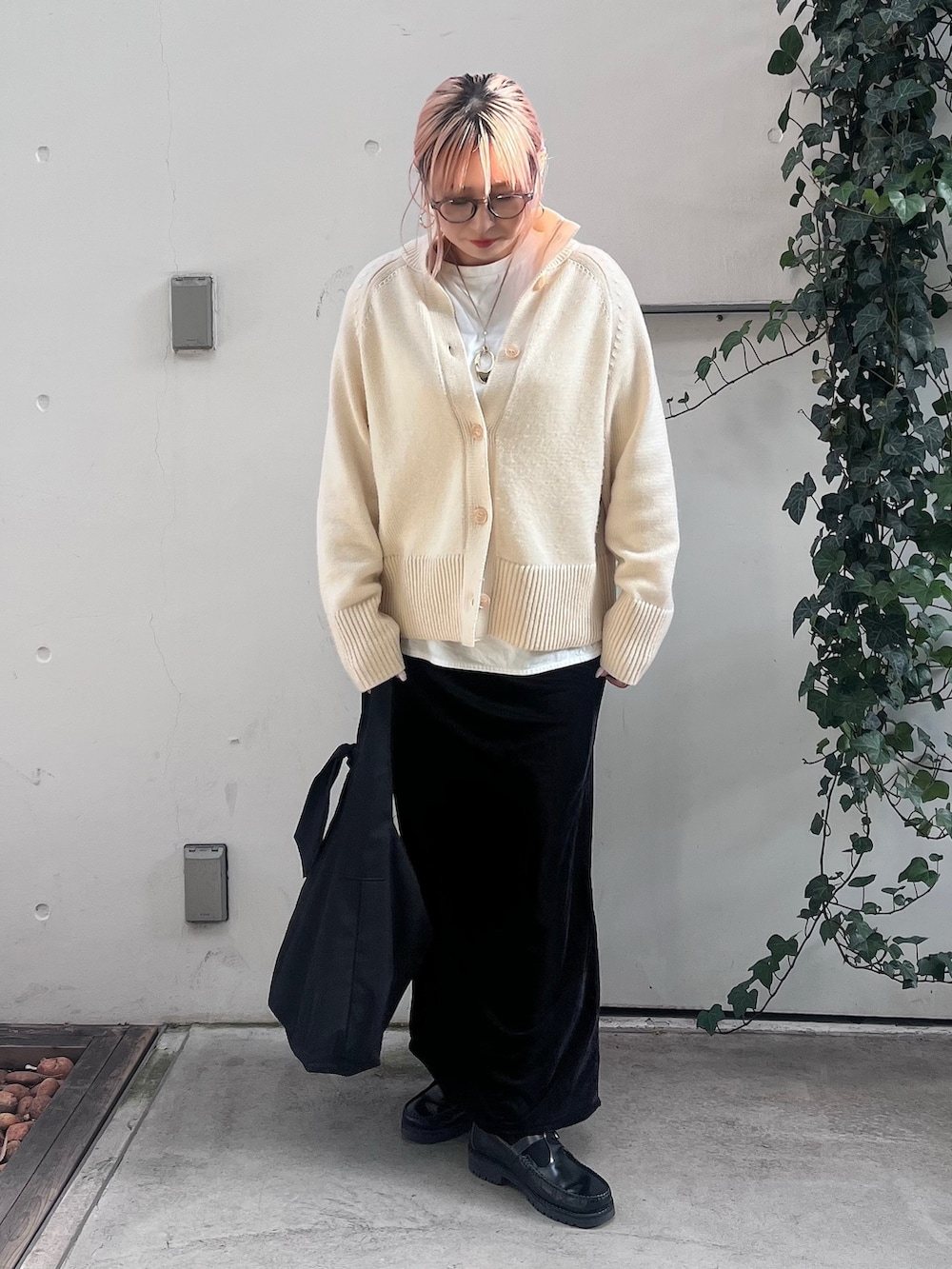 ホワイト系のニット/セーター、ホワイト系のTシャツ/カットソー、ブラック系のトートバッグを着用したレディースの冬コーディネートの4枚目の写真