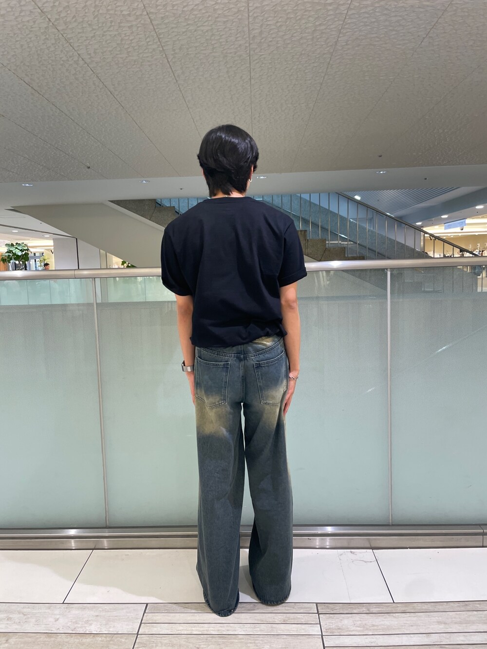 ブラック系のTシャツ/カットソー、ブルー系のデニムパンツを着用したメンズの夏コーディネートの3枚目の写真