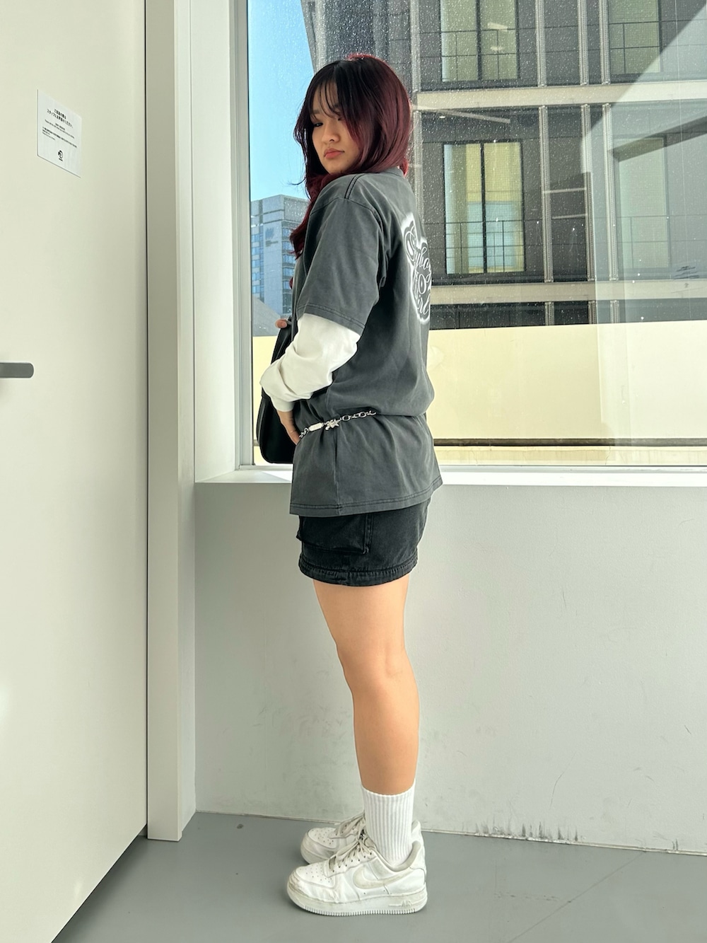 ブラック系のショルダーバッグ、ブラック系のスカート、ブラック系のTシャツ/カットソーを着用したレディースの冬コーディネートの3枚目の写真