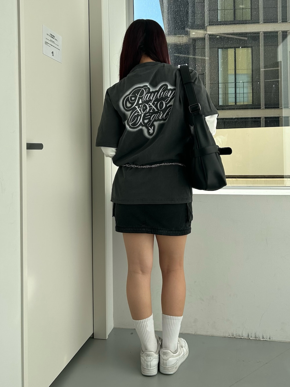 ブラック系のショルダーバッグ、ブラック系のスカート、ブラック系のTシャツ/カットソーを着用したレディースの冬コーディネートの2枚目の写真