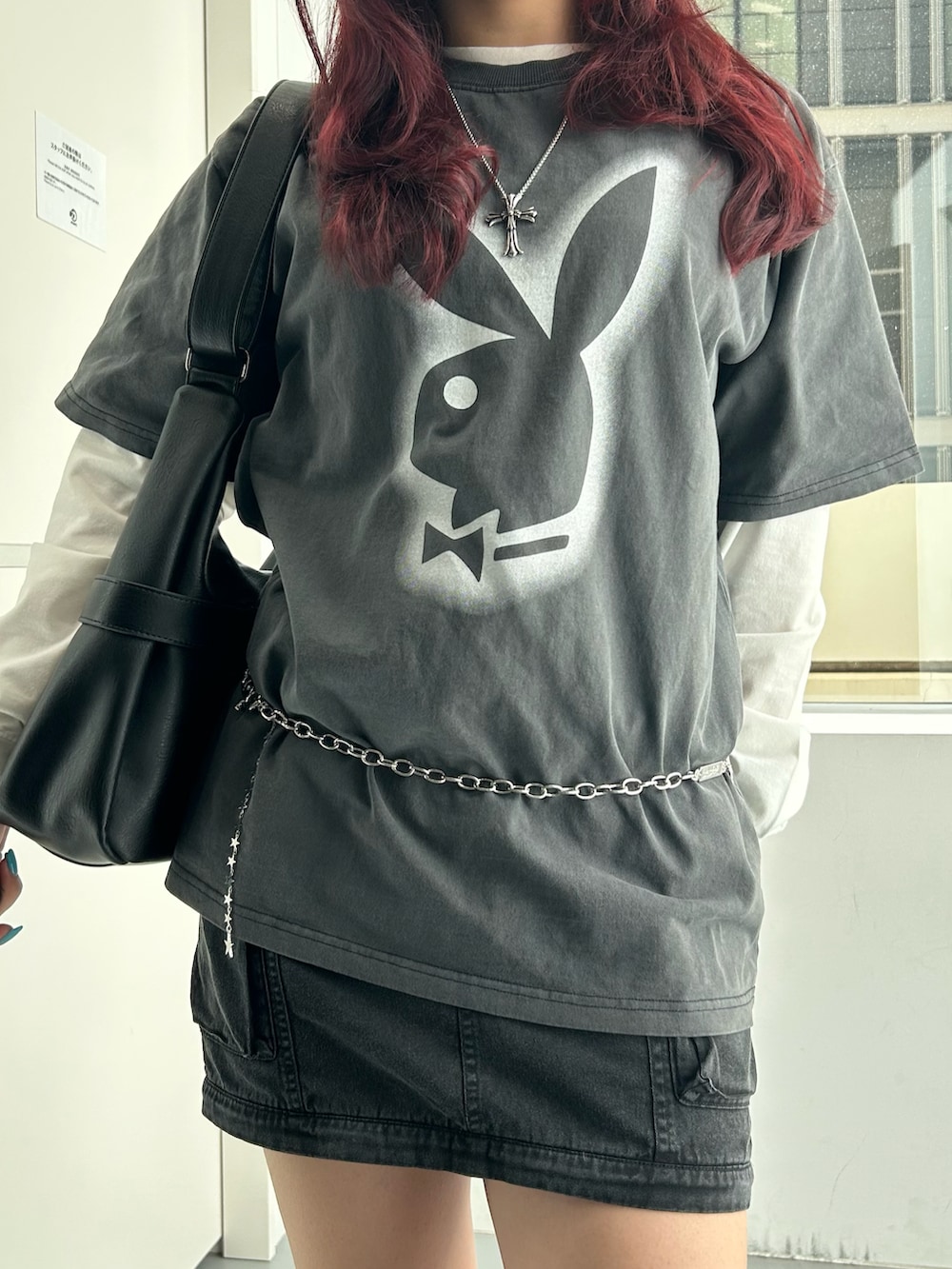 ブラック系のショルダーバッグ、ブラック系のスカート、ブラック系のTシャツ/カットソーを着用したレディースの冬コーディネートの5枚目の写真