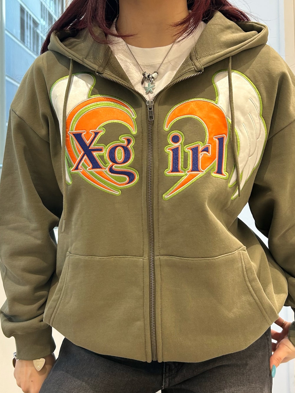 グリーン系のパーカー、ブラック系のデニムパンツ、ホワイト系のTシャツ/カットソーを着用したレディースの冬コーディネートの4枚目の写真