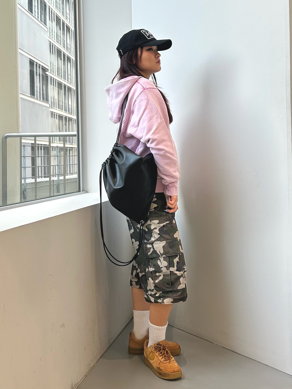 その他のカーゴパンツ、ピンク系のパーカー、ブラック系のバックパック/リュックを着用したレディースの冬コーディネートの2枚目の写真