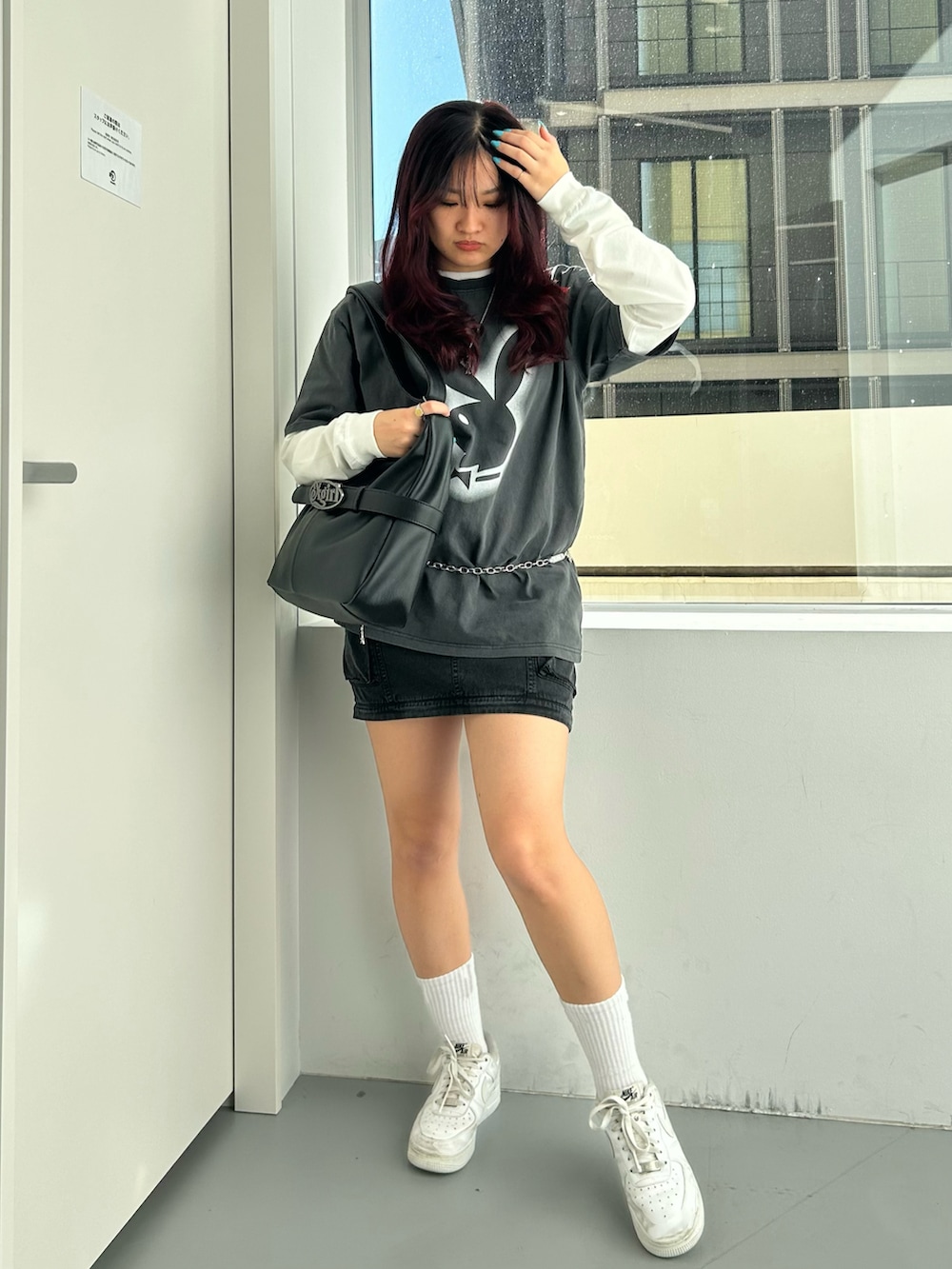 ブラック系のショルダーバッグ、ブラック系のスカート、ブラック系のTシャツ/カットソーを着用したレディースの冬コーディネートの4枚目の写真