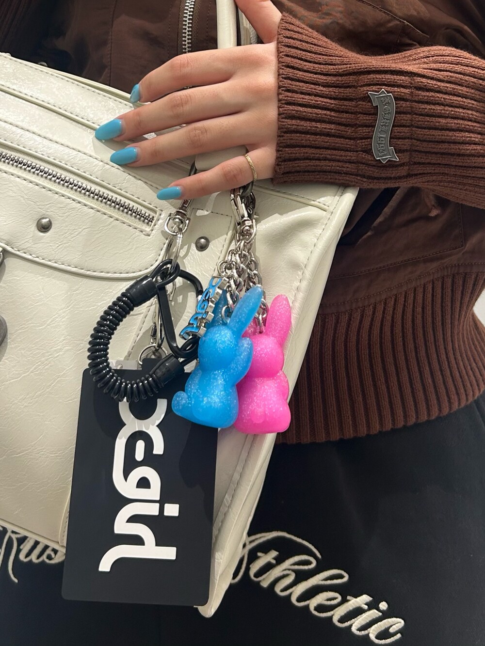 ブラウン系のブルゾン、ブラック系のスウェットパンツ、ホワイト系のショルダーバッグを着用したレディースの冬コーディネートの4枚目の写真