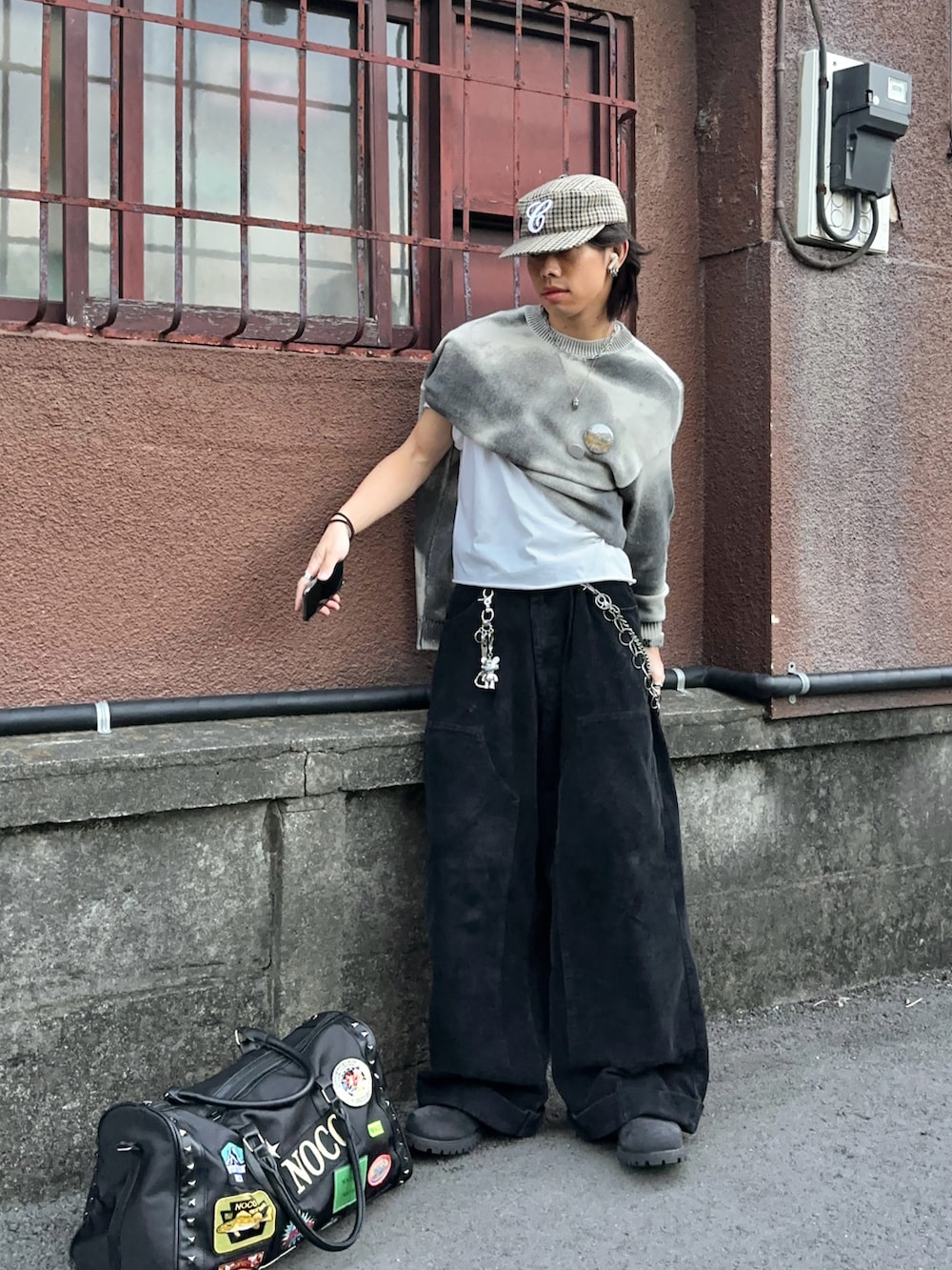 ブラック系のボストンバッグ、ブラック系のデニムパンツ、ブラック系のブーツを着用したメンズの秋コーディネートの2枚目の写真