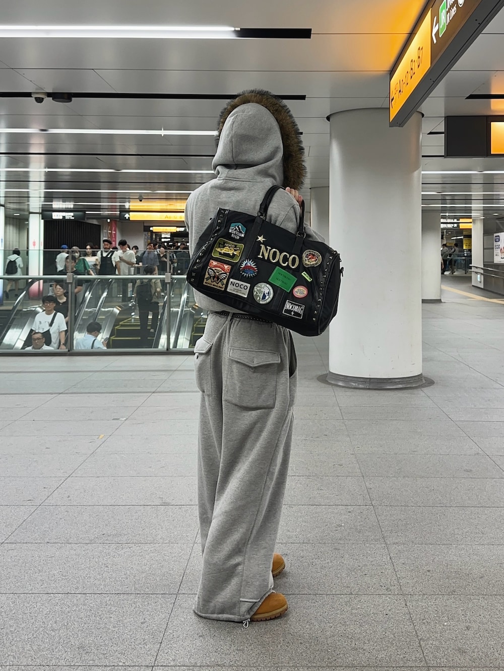 グレー系のスウェットパンツ、イエロー系のブーツ、ブラック系のボストンバッグを着用したメンズの秋コーディネートの2枚目の写真